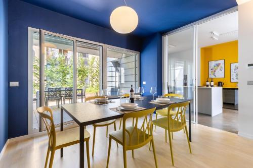 a dining room with blue walls and a table and chairs at Casa Conca in Alba