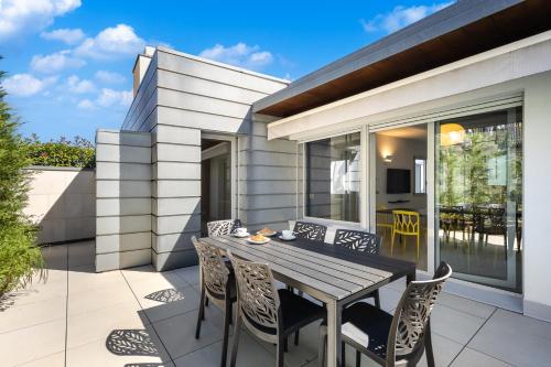 a patio with a wooden table and chairs at Casa Conca in Alba
