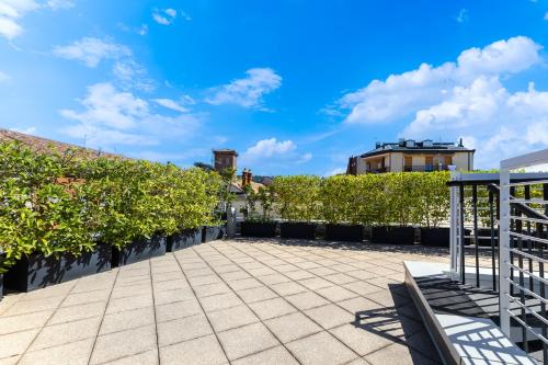 a patio with a fence and bushes at Casa Conca in Alba