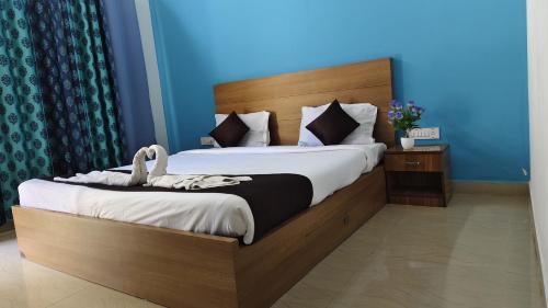 a bedroom with a large bed with a wooden headboard at Rithu Beach Villa in Alleppey