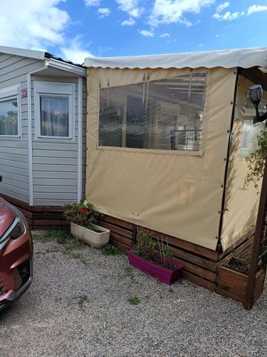 une tente beige installée à côté d'une maison dans l'établissement Le petit paradis, à Fréjus