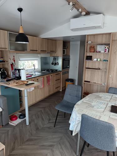 une cuisine et une salle à manger avec une table et des chaises dans l'établissement Le petit paradis, à Fréjus