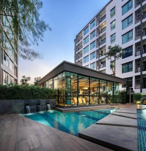 a building with a swimming pool in front of a building at 素坤逸50巷一房一厅免费Wi-Fi简单安静可做饭交通方便 in Amphoe Phra Khanong