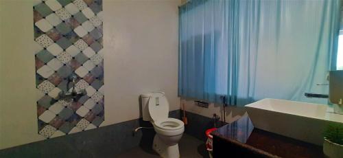 a bathroom with a toilet and a sink at Thomson by the Beach in Candolim