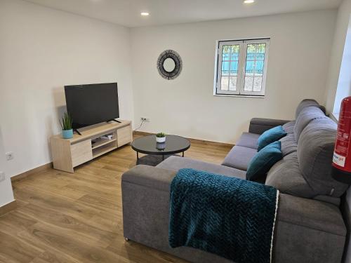 a living room with a couch and a tv at Destro village in Lindoso