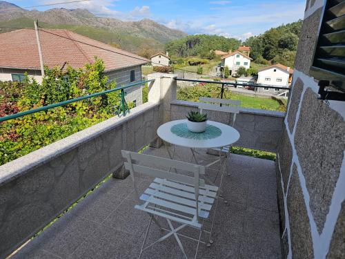 a table and a chair on a balcony with mountains at Destro village in Lindoso