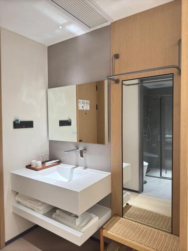 a bathroom with a white sink and a mirror at Constellation XingSu Boutique Hotel in Huangshan