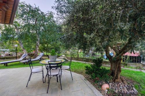 a patio with a table and chairs under a tree at Villa Tanya in Verrès