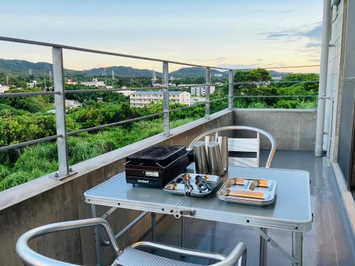 a table with plates of food on a balcony at CondoYumangi in Onna