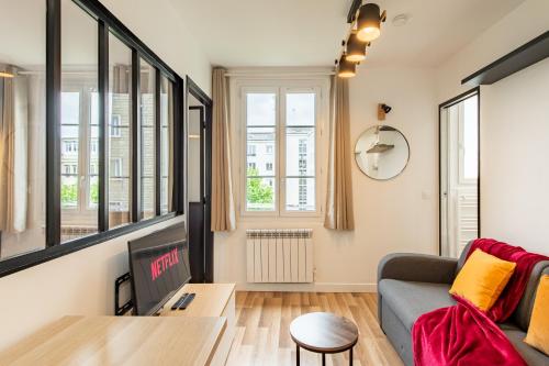 un salon avec un canapé et une télévision dans l'établissement Cozy 1-bedroom apartment with all amenities near iconic Montmartre neighbourhood, à Paris