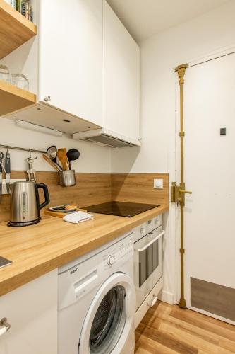 une cuisine avec une machine à laver dans une cuisine dans l'établissement Cozy 1-bedroom apartment with all amenities near iconic Montmartre neighbourhood, à Paris