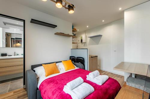 - une chambre dotée d'un grand lit avec des oreillers orange et blancs dans l'établissement Cozy 1-bedroom apartment with all amenities near iconic Montmartre neighbourhood, à Paris
