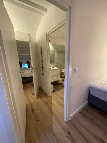 - une chambre avec un miroir, un lit et une salle de bains dans l'établissement Mini Villa T4 duplex dans résidence hôtelière superbement arborée rénovée en 2023 - chez Anne avec piscine chauffée, à Lecci