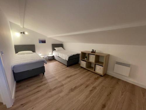 une chambre avec deux lits et un parquet dans l'établissement Mini Villa T4 duplex dans résidence hôtelière superbement arborée rénovée en 2023 - chez Anne avec piscine chauffée, à Lecci