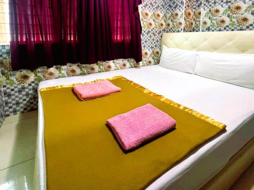 a bed with two pink towels on it at Ark Batu Caves Bussines Hotel in Batu Caves