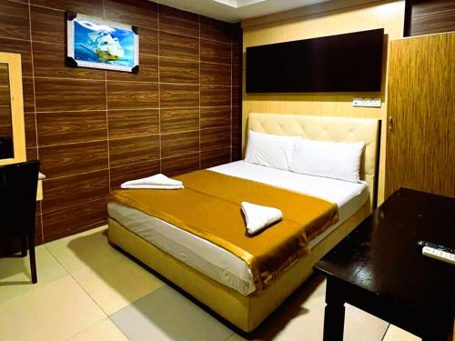 a bedroom with a bed with a television on the wall at Ark Batu Caves Bussines Hotel in Batu Caves
