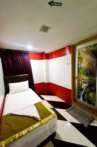 a bedroom with a bed and a painting on the wall at Ark Batu Caves Bussines Hotel in Batu Caves