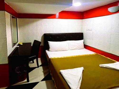 a small room with a bed and a desk at Ark Batu Caves Bussines Hotel in Batu Caves
