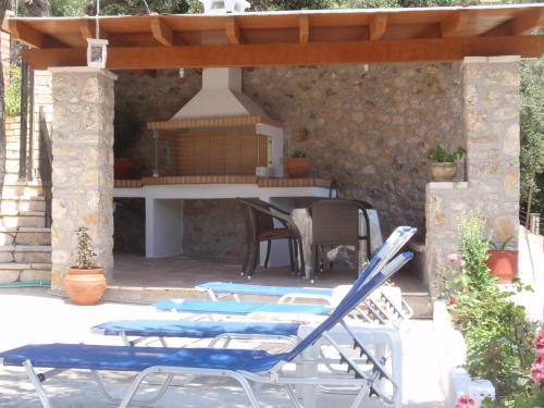 a patio with chairs and a table and a grill at Korina Studios in Paleokastritsa