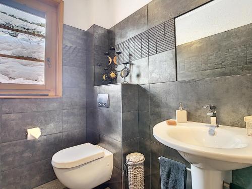 a bathroom with a toilet and a sink at Sentio Chalet in Ollon