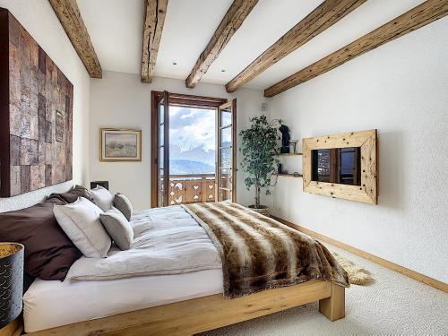 a bedroom with a large bed and a window at Sentio Chalet in Ollon