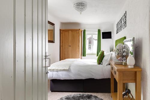 ein Schlafzimmer mit einem Bett und einem Tisch und einem Fenster in der Unterkunft heft view at rose cottage - opp heft restaurant in Grange Over Sands