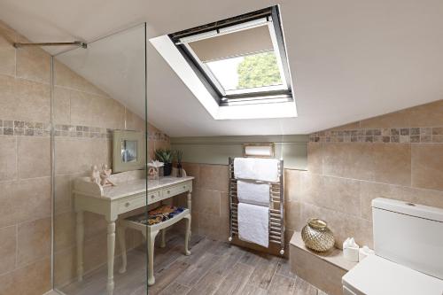 ein Badezimmer mit einem Waschbecken und einer Dusche mit einem Dachfenster in der Unterkunft heft view at rose cottage - opp heft restaurant in Grange Over Sands