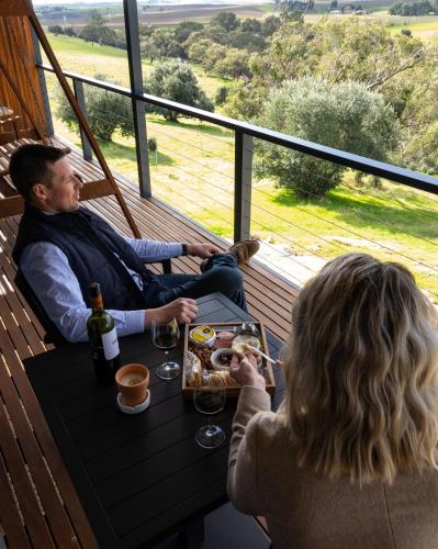 a man and a woman sitting at a table with food and wine at Barossa Pavilions & Glasshouse in Lyndoch