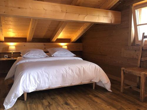 une chambre avec un lit dans une cabane en bois dans l'établissement L'Arpa - Duplex dans Chalet Neuf - Vue MontBlanc, à Hauteluce