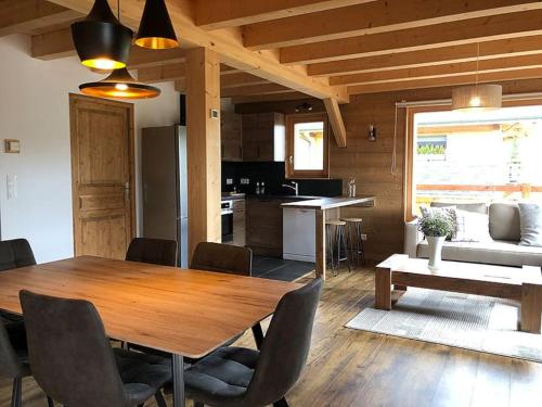 - une salle à manger et une cuisine avec une table et des chaises en bois dans l'établissement L'Arpa - Duplex dans Chalet Neuf - Vue MontBlanc, à Hauteluce