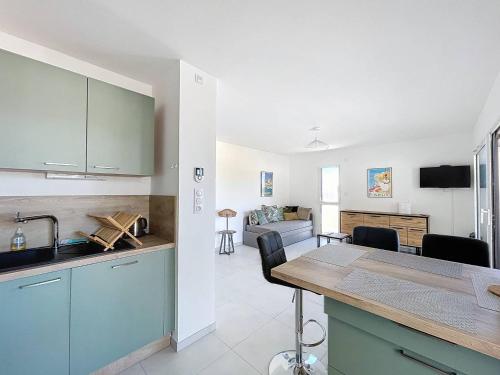 une cuisine avec des armoires bleues et un salon dans l'établissement T2 - Résidence avec piscine, à Calvi