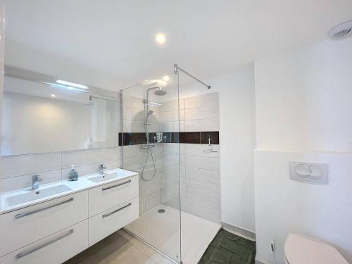 une salle de bain blanche avec un lavabo et une douche dans l'établissement T2 - Résidence avec piscine, à Calvi