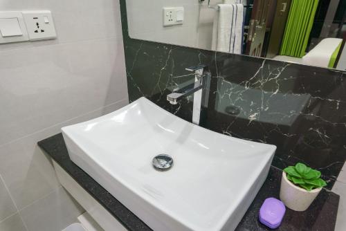 a white sink in a bathroom with a mirror at Green Vibe Apartments in Nugegoda