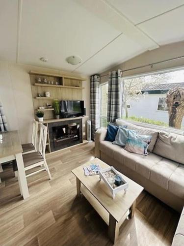 a living room with a couch and a table at Chalet Steffis Casa del Sol Renesse in Renesse