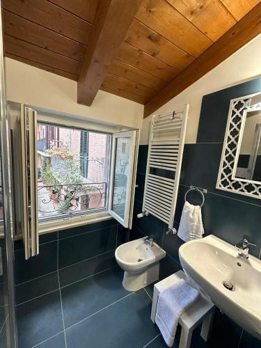 a bathroom with a sink and a toilet and a window at Colle Rooms HELIANTHUS in Santa Maria degli Angeli