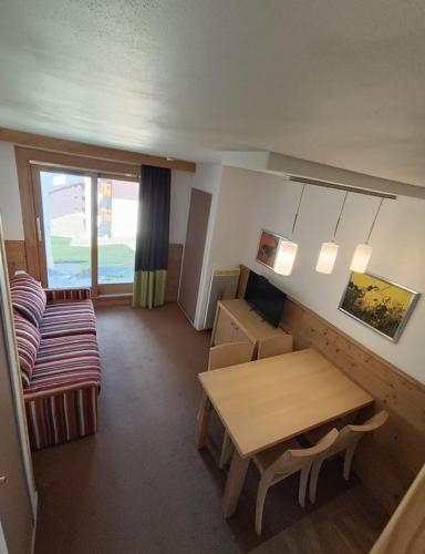 un salon avec une table et un canapé dans l'établissement 4-6 personnes Les Gémeaux - Skis aux pieds, à La Plagne Tarentaise