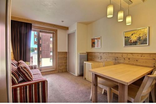 une salle à manger avec une table en bois et une fenêtre dans l'établissement 4-6 personnes Les Gémeaux - Skis aux pieds, à La Plagne Tarentaise