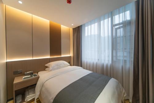 a bedroom with a bed and a window at Lucky Praised Scenery Hotel in Zhangjiajie