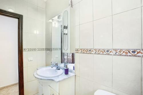 a white bathroom with a sink and a mirror at Villa Palomino - Sleeps 6 - Parking - Pet Friendly in Gáldar