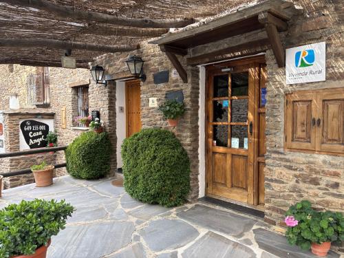 a building with a wooden door and a sign on it at Ático Casa Ángel in Bubión