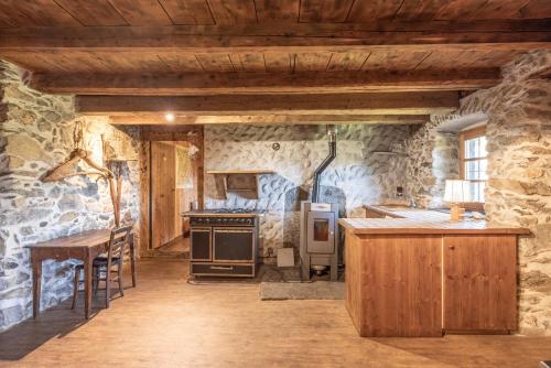 - une cuisine avec des murs en pierre et un four avec plaques de cuisson dans l'établissement Chalet d'alpage Cornillon, à Cordon