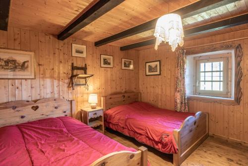 deux lits dans une chambre aux murs en bois dans l'établissement Chalet d'alpage Cornillon, à Cordon