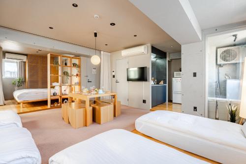 a bedroom with two beds and a table in a room at STAY ARI Shinjuku Takadanobaba Design awarded in Tokyo