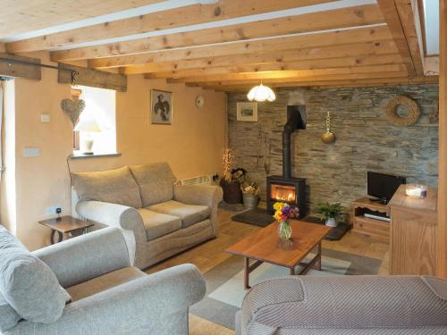 a living room with a couch and a fireplace at Y Cartws Cardigan in Cardigan