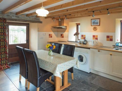 a kitchen with a table and a washing machine at Y Cartws Cardigan in Cardigan