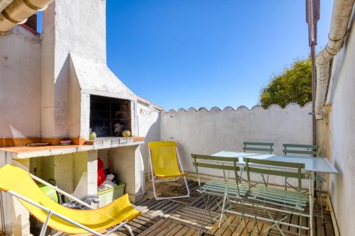 a patio with yellow chairs and a table and chairs at Siesta Sete in Sète