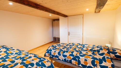 a bedroom with two beds and a wooden ceiling at Gite de montredon in Cubières