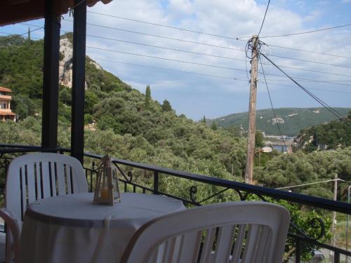 a table and chairs on a balcony with a view at Korina Studios in Paleokastritsa