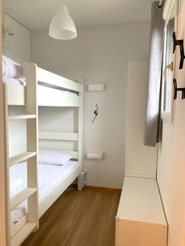 une chambre avec deux lits superposés et un placard dans l'établissement Appartement 4-6 pers - Station Super-Besse, à Super-Besse