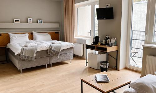 a bedroom with a bed and a table and a tv at LaSpa in Laulasmaa